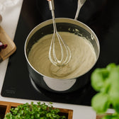 Pisket bearnaise sauce i kasserolle på komfur