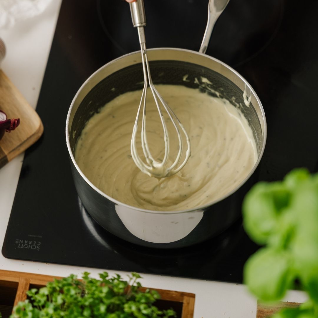 Pisket bearnaise sauce i kasserolle på komfur