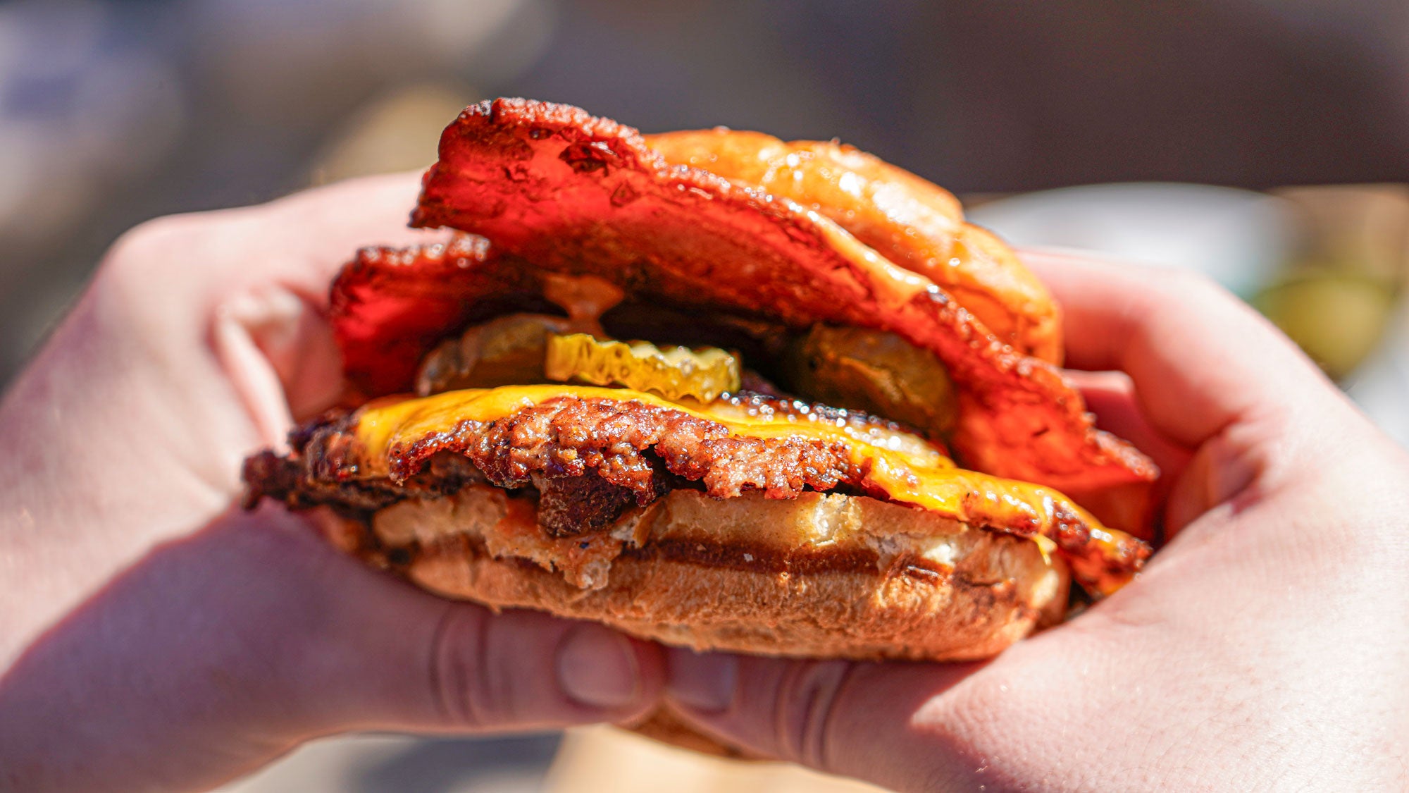 Nærbillede af double smash burger med bacon lavet på grillen