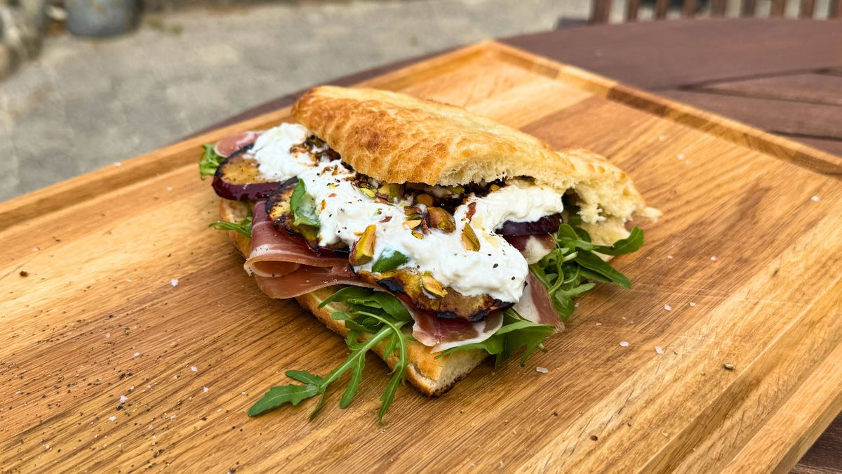 Focaccia med grillede nektariner og seranoskine anrettet på skærebræt