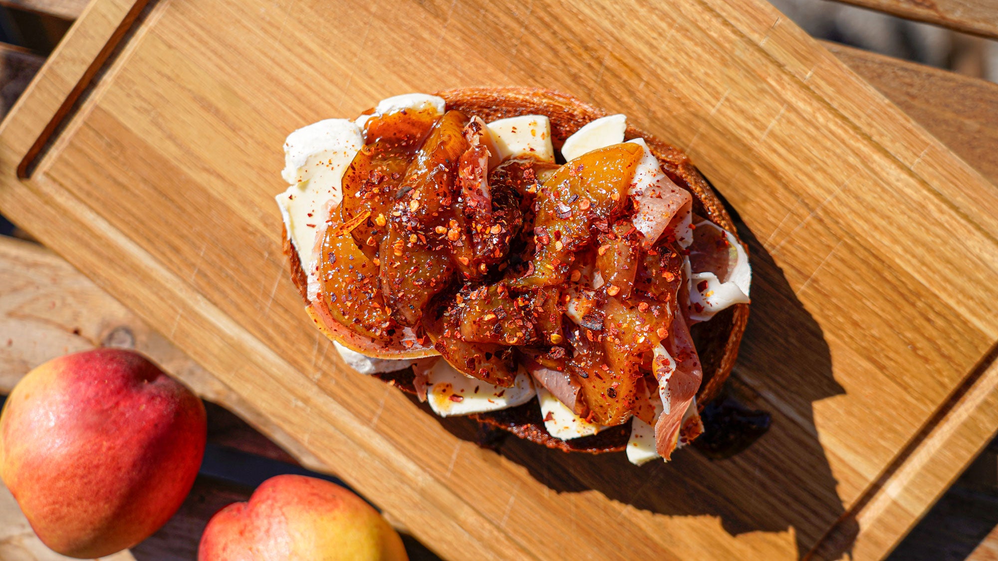 Ristet surdejsbrød med brie og parmaskinke anrettet på skærebræt i egetræ