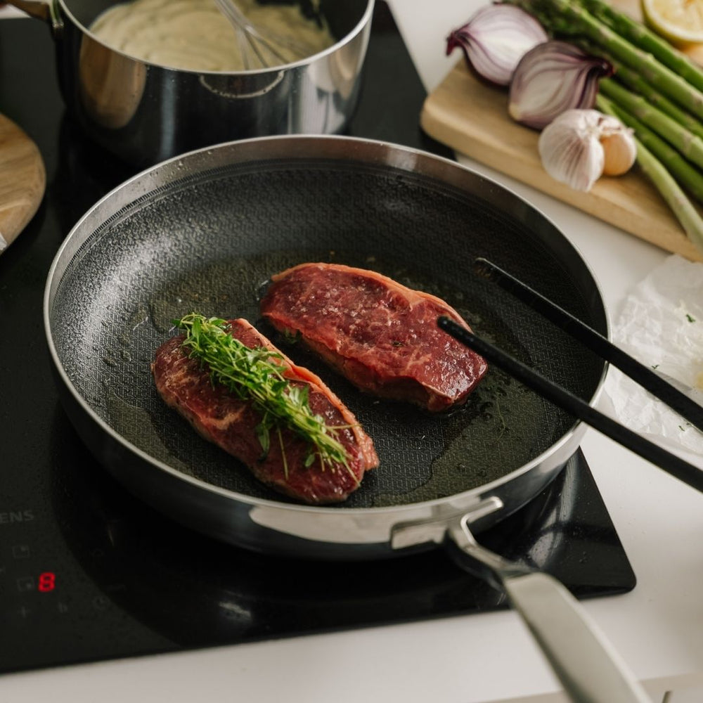 Bøffer på stegepande på komfur