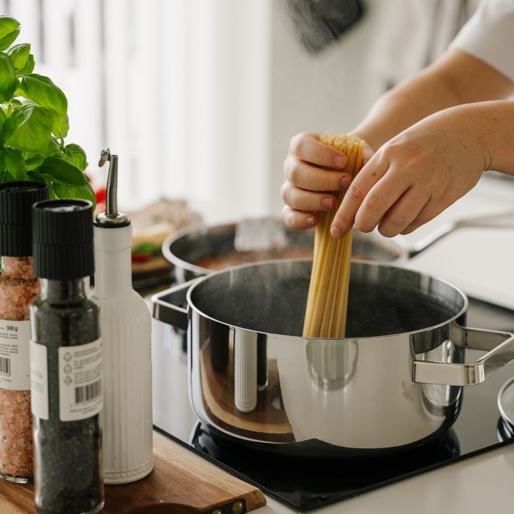 Gryde med spaghetti på komfur