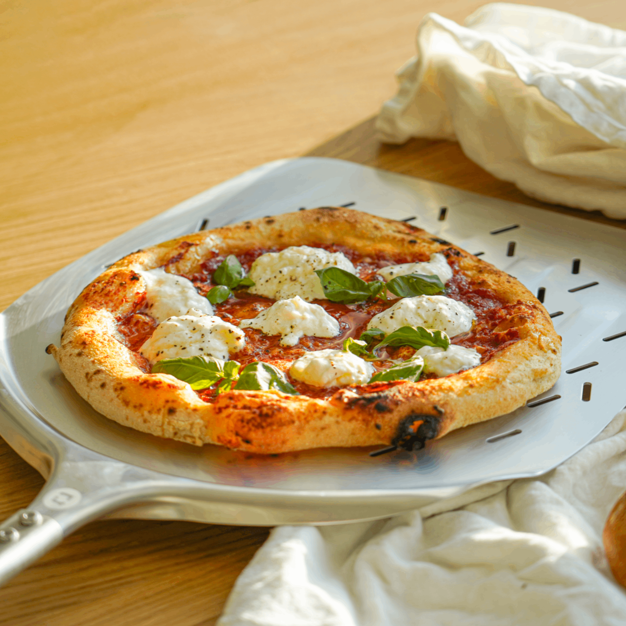 Surdejspizza på pizzaspade liggende på bord