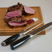 Miljøbillede med forskærersæt på skærebræt med kød