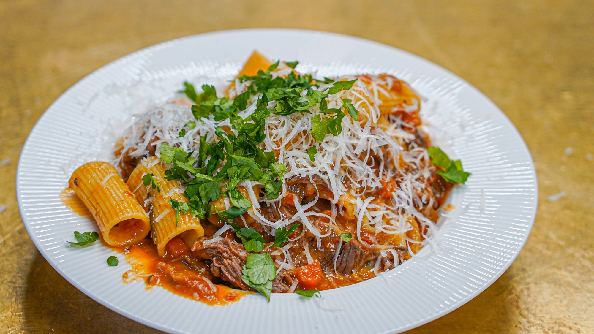 Rigatoni med oksekød anrettet i dyb tallerken