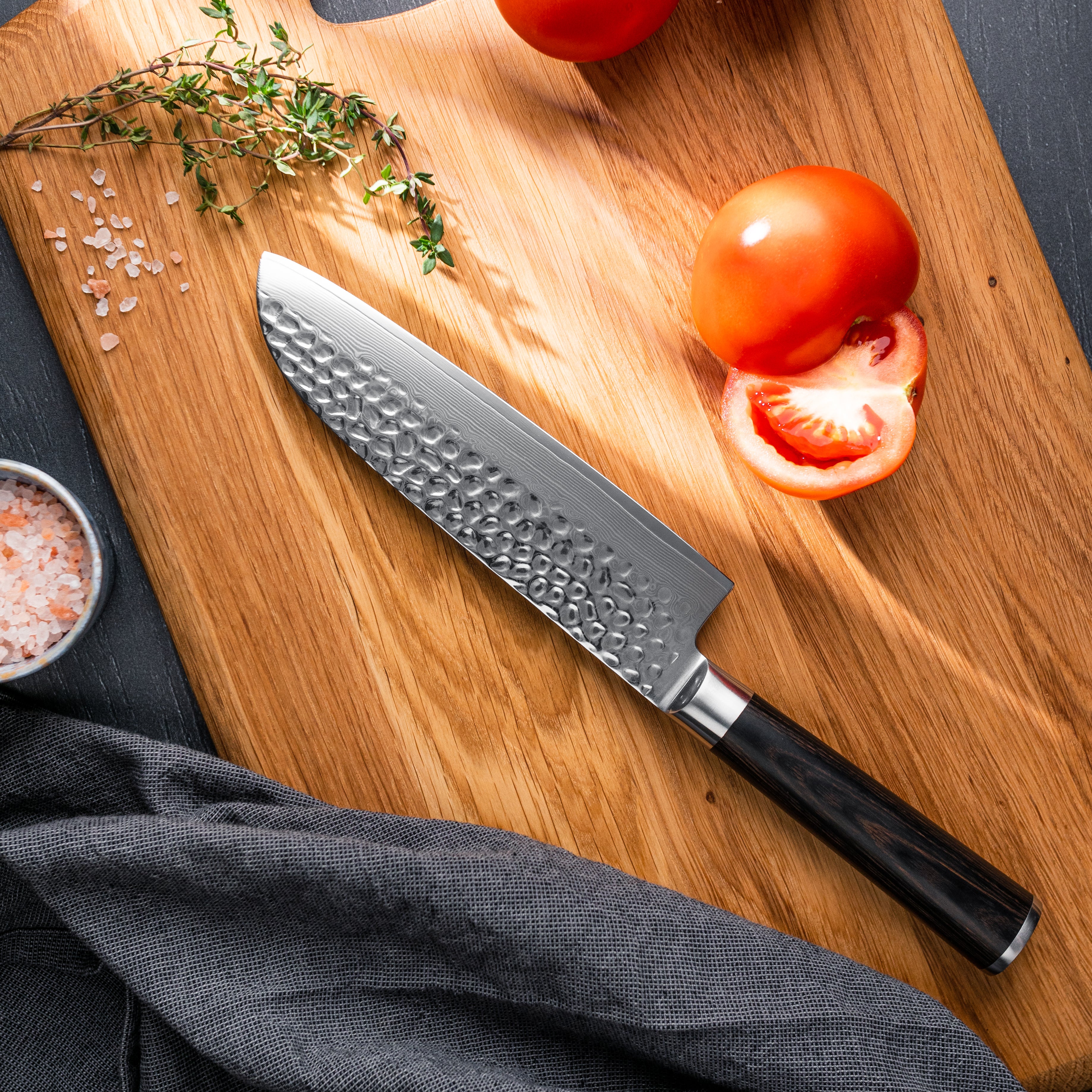 Santoku kniven er lavet i 67 lags stål og med et skæfte i pakkatræ